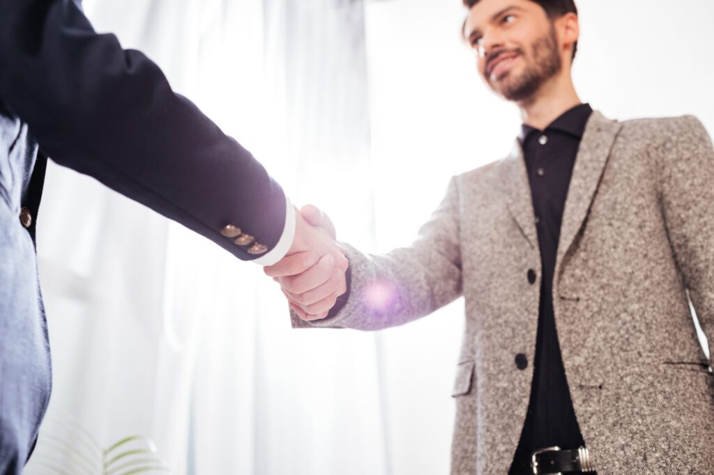 Close up photo of men business handshake in office